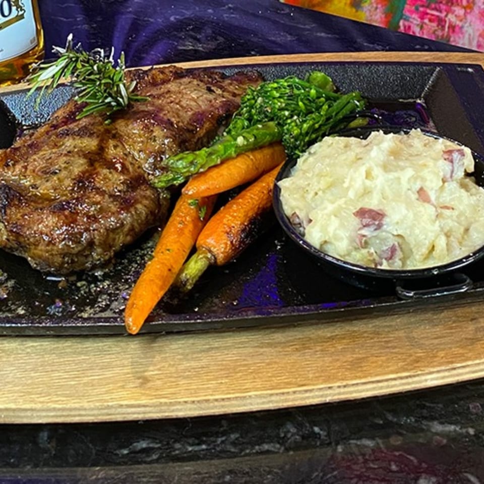 Grilled steak with rosemary, roasted carrots, asparagus, and a side of mashed potatoes.