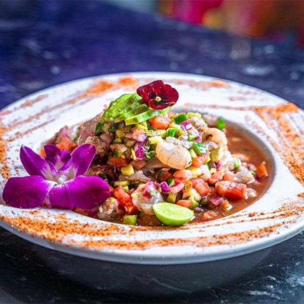 Culichis Urban Kitchen's colorful Mexican ceviche with shrimp, avocado, and lime, garnished with flowers.